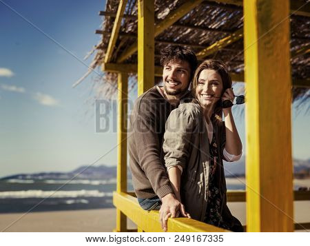 Happy couple enyojing time together on beach during autumn day colored filter