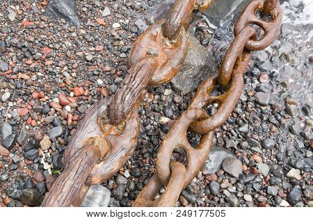 Two Old Rusty Shipping Chains On The Seashore