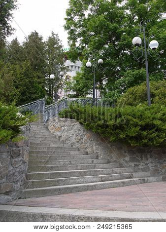 A Staircase With Tapering Upstairs Steps With Side Lamps For Lighting At Night Leading Up To The Hot