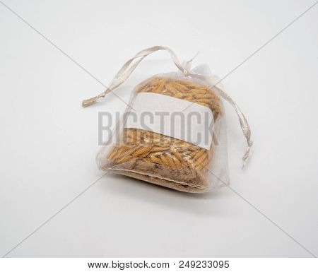 Rice Bran In See Through Net Fabric Bag Isolated On White Background With Copy Space.