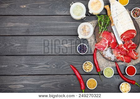 Sliced Cured Coppa With Spices And A Sprig Of Rosemary.