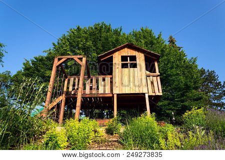 Beautiful Wooden Children Playhouse With Swing And Slide On Hillside