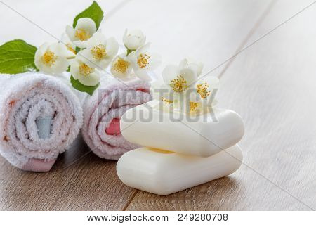 White Towels And Soap For Bathroom Procedures Decorated With Flowers Of Jasmine On Wooden Boards. Sp