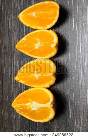 Orange Fruit. Four Orange Slice And Pieces Isolate On Black Wood.