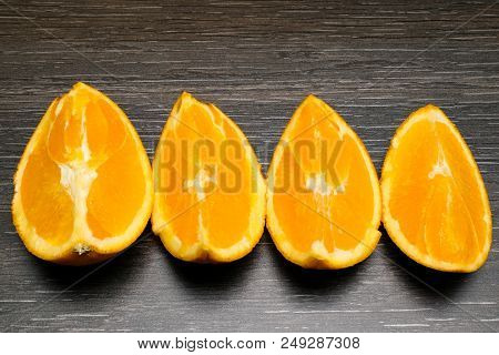 Orange Fruit. Four Orange Slice And Pieces Isolate On Black Wood.