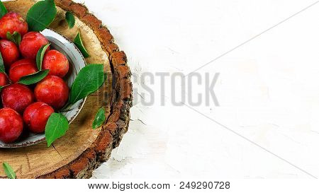 Red Ripe Plums On A Wooden Stump, Light Background. Flat Lay, Space For Text.