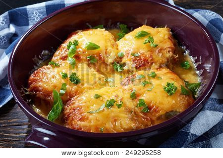 Pork Chops Topped With Onions, Mayo And Cheese In A Baking Dish On A Old Dark Wooden Table, View Fro