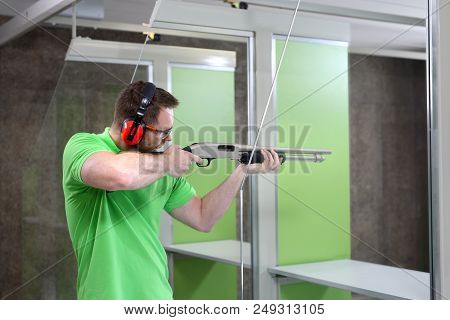 Shoots From The Rifle.
The Man Shoots From The Rifle. Handsome Man Trains Shooting At The Sports Sho