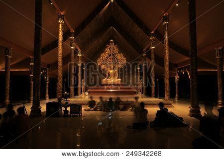 Golden Color Meditating Gautama Buddha Ststue Image With Two Disciples Praying In The Front And Bodh