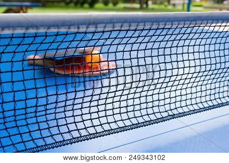 Pingpong Rackets And Ball And Net On A Blue Pingpong Table