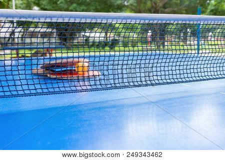 Pingpong Rackets And Ball And Net On A Blue Pingpong Table