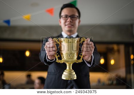 Asian Businessman Holding A Golden Trophy Cup To Cheerful And Celebrated His Successful In Career An