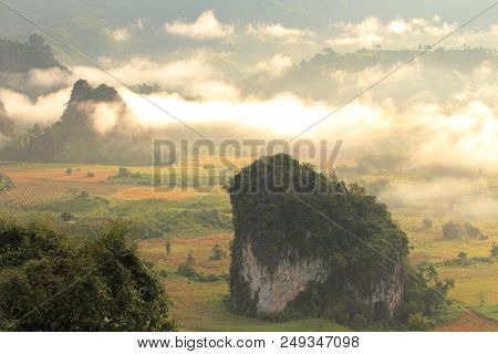 Rock Mountain Protruding From Rice Field. Morning Fog On Sunrise In The Phulanka, Phayao Thailand.