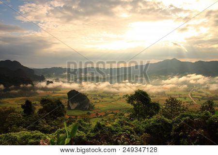 Rock Mountain Protruding From Rice Field. Morning Fog On Sunrise In The Phulanka, Phayao Thailand.
