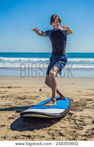 Young Man Surfer Training Before Go To Lineup On A Sand Beach. Learning To Surf. Vacation Concept. S