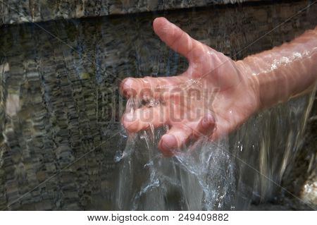 Teenager's Hand Under Cascade Of Running Water