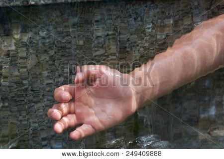 Teenager's Hand Under Cascade Of Running Water