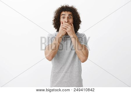 Portrait Of Amazed Anxious Hispanic Male Model With Afro Hairstyle, Staring With Popped Eyes And Cov