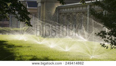 Automatic Sprinkler System Watering The Lawn On A Background Of Green Grass, Close-up