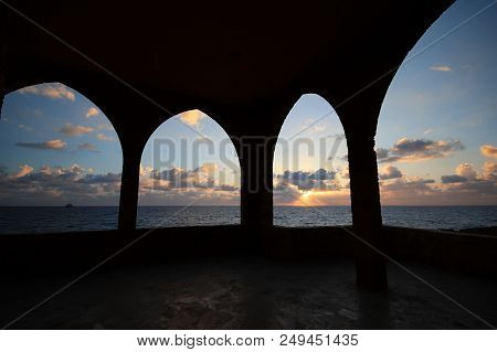 View Of The Sunset Over The Mediterranean Sea Through Arches In Batroun, Lebanon.