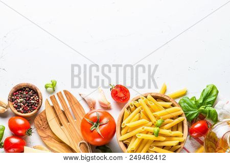 Food Cooking Ingredients Background. Pasta, Tomatoes, Herbs And Vegetables On White Table. Top View 