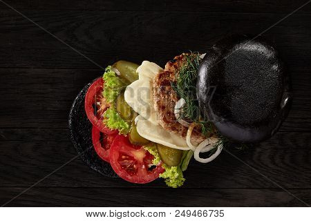 Black Burger On Vintage Wooden Background, Top View, Close-up, Selective Focus. Artistic Layout. Exo