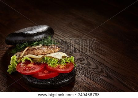 Black Burger On Vintage Wooden Background, Top View, Close-up, Selective Focus. Artistic Layout. Exo