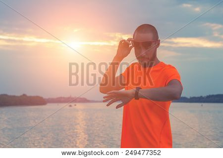 Checking The Time After Exercising / Jogging Outdoors. Optical Focus Is On The Hand And Watch.