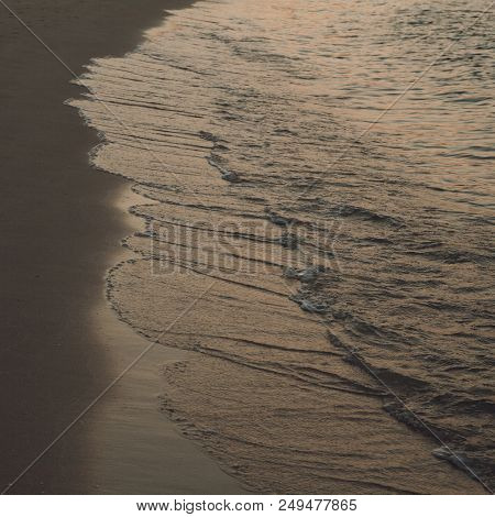 Waves Wash Over Golden Sand On Beach.