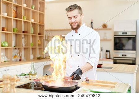 Waist Up Portrait Of Smiling  Professional Chef Working In Modern Restaurant Kitchen Standing At Woo