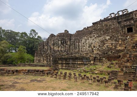Ancient Khmer Temple View In Angkor Wat Complex, Cambodia. Buddha Face On Phnom Bakheng Temple Wall.