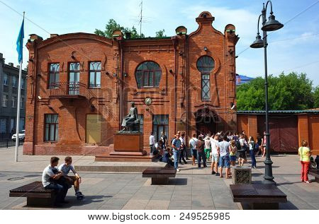 Omsk, Russia - 12 July, 2018: Crowd of people next to old red brick building of consulate of republic of Kazakhstan in Russian city Omsk