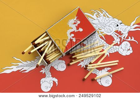 Bhutan Flag  Is Shown On An Open Matchbox, From Which Several Matches Fall And Lies On A Large Flag.
