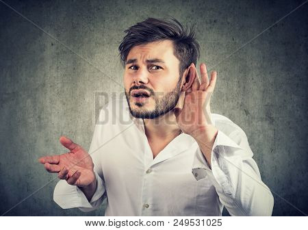 Frowning Young Man Having Problems With Hearing And Looking At Camera In Misunderstanding Gesturing 