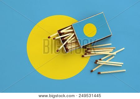 Palau Flag  Is Shown On An Open Matchbox, From Which Several Matches Fall And Lies On A Large Flag.