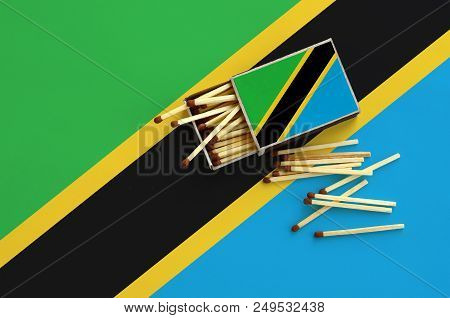 Tanzania Flag  Is Shown On An Open Matchbox, From Which Several Matches Fall And Lies On A Large Fla