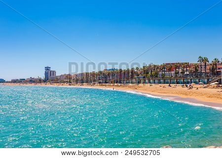 Barceloneta Beach In Barcelona. Nice Sand Beach With Palms. Sunny Bright Day With Blue Sky. Famous T