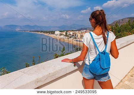 Young Tourist Woman On The Beach And Sea Landscape With Sperlonga, Lazio, Italy. Scenic Resort Town 