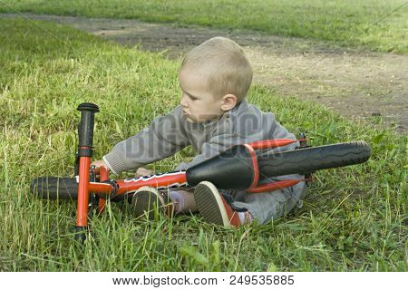 A Little Boy Dreams Of Becoming A Mechanic. The Guy Trains On A Bicycle. The Child Spins The Nuts On