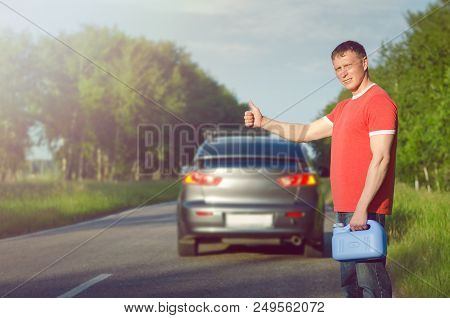 Driver Standing With Empty Fuel Canister Against Car Background. Finished Fuel. Not Enough Gasoline.
