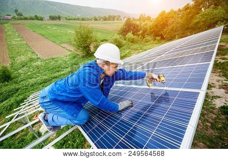 Construction Worker Connects Photo Voltaic Panel To Solar System Using Screwdriver. Professional Ins