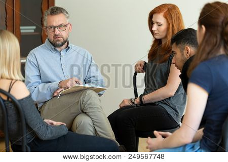 Serious Teacher Talking To A Group Of Rebellious Teenagers In School Detention