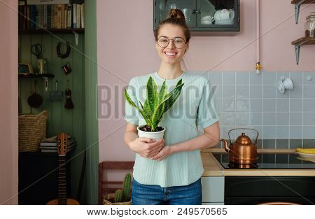 Closeup Portrait Of Attractive Caucasian Girl Pictured At Home Wearing T-shirt, Jeans And Trendy Eye