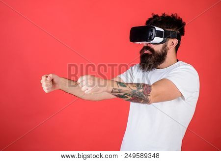 Virtual Racing Concept. Man With Beard In Vr Glasses Driving Car, Red Background. Hipster On Concent