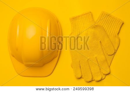 Yellow Construction Helmet On Yellow Background, Next To Yellow Gloves, Head And Hand Protection, Co