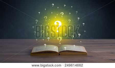 Yellow question marks hovering over open book 