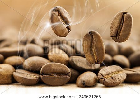 Flying Fresh Coffee Beans As A Background With Copy Space. Coffee Beans Falling Down With White Stea