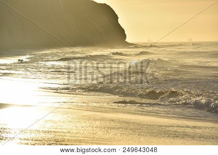 Crashing Waves Glistening From The Sunrise On The Water