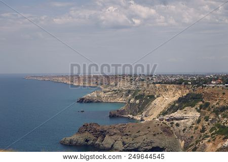 Panoramic View Of Craggy Coastline With Small Towns By Peaceful Blue Sea. Seascape And Long Rugged S