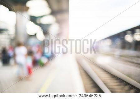 Blurred Image With Passengers Waiting Train On Platfom At Railway Station. Tourists With Baggage.